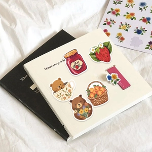 Cute forest animal stickers set with bear and fruit designs on a decorative notebook