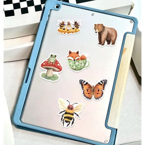 Close-up of cute forest animal stickers on a blue tablet case showing fox and bear details