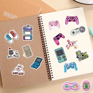 Classic gaming console stickers on notebook showing vintage controller designs
