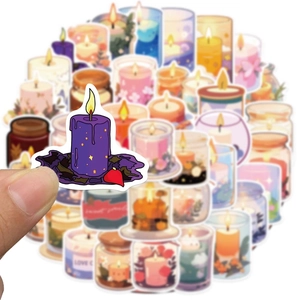 Close-up showing a hand holding a colorful waterproof PVC candle-themed sticker for journals