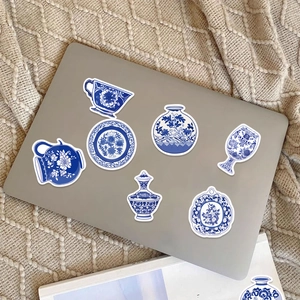 Detailed blue and white porcelain stickers displayed on a silver laptop surface