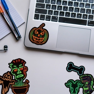 Autocollants néon Halloween sur un ordinateur portable avec citrouilles et crânes