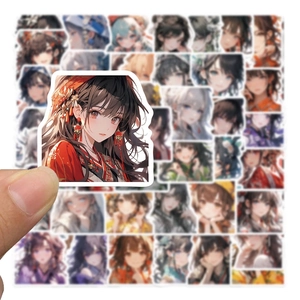 Détail montrant un autocollant de fille anime tenu à la main sur divers stickers