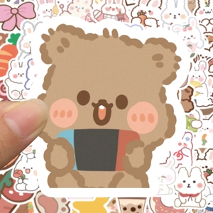 Detail of a cute cartoon bear sticker with game console being held to show small size scale