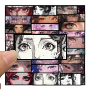 Detail shot of anime eye stickers being applied to a surface with hand-held demonstration