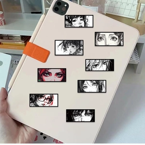 Detail of 8 anime eye stickers applied on a beige tablet case in a desk setting