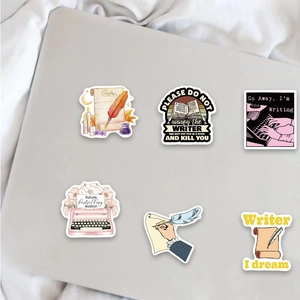 Close-up of vintage typewriter and literary stickers on a laptop surface