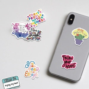 Close-up of colorful waterproof motivational quote stickers on a grey smartphone case