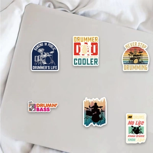 Detailweergave van drummerstickers op een laptop met rockmuzikant-ontwerpen en slogans