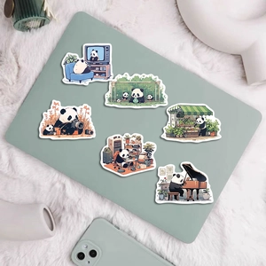 Detail showing cartoon panda stickers applied to a green laptop with waterproof PVC texture