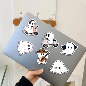 Close-up of cute ghost stickers applied on a laptop case featuring various cartoon poses