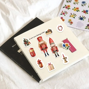 Detail of Christmas nutcracker stickers with watercolor patterns on white book cover