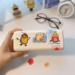 Waterproof cartoon potato stickers on a beige hardshell stationery box held by hand