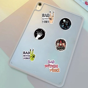 Detail showing Bad Witch Vibes stickers on a tablet with crystal ball and witch patterns