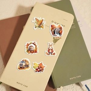 Detailed view of autumn stickers with hedgehog and rabbit on a beige notebook cover
