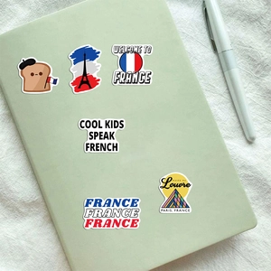 Close-up of waterproof French travel stickers on a notebook cover with Eiffel Tower designs