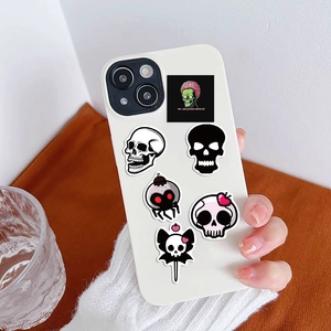 Coque de téléphone blanche avec stickers graffiti tête de mort et alien tenue à la main