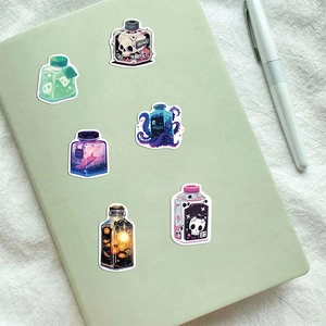 Detail of fantasy juice bottle stickers with kraken and skull designs on a notebook