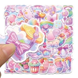 Close-up of hand holding a cute macaron-colored dessert sticker with bow and cloud patterns