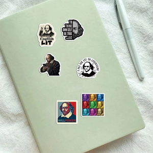 Detail view of waterproof Shakespeare stickers on a green notebook with a pen