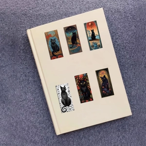 Set d'autocollants chats noirs artistiques avec illustrations vintage sur un livre ivoire