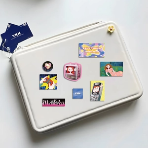 Detailed view of DIY stickers on white laptop sleeve with Y2K aesthetic designs