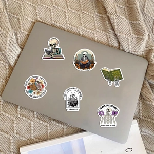 Autocollants de crâne de lecture étanches sur un ordinateur portable et couverture