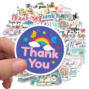 Close-up of hand holding colorful floral thank you stickers for packaging sealing
