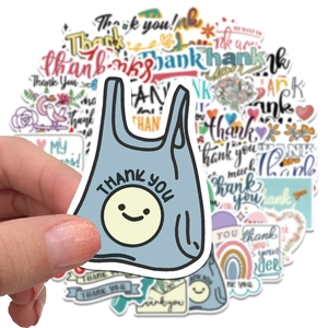 Close-up of assorted thank you stickers with a smiling face shopping bag design