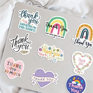 Set of 50 colorful hand-drawn thank you stickers for business packaging on a laptop
