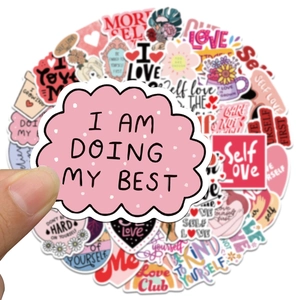Close-up of Self Love Club stickers with pink heart designs and positive quotes