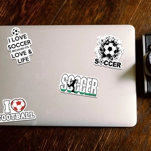 Detail of soccer themed stickers on a laptop featuring I Love Soccer slogans and icons