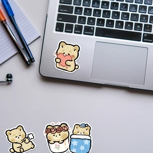 Cute cartoon brown bear stickers applied on laptop keyboard for creative decoration
