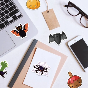 100pcs Halloween stickers set with cute pumpkin and bat designs on a laptop