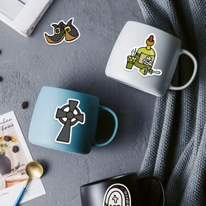 Detail shot of gothic Halloween stickers with witch shoes and skull potions on a mug