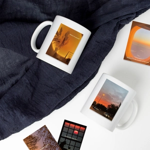 Detailed view of two ceramic sunset mugs and matching photo cards with inspirational quotes