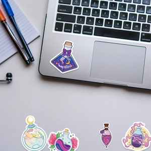 Close-up of fantasy magic potion stickers on a silver laptop for creative decoration