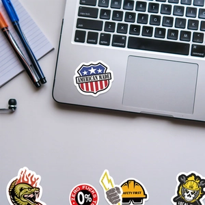 Detail shot of vinyl stickers on a laptop featuring patriotic and industrial designs