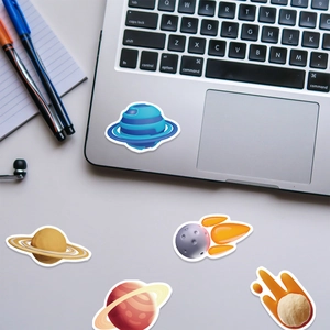 Close-up of space planet stickers on a laptop and desk for creative decoration
