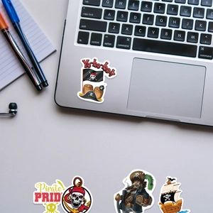 Cartoon pirate stickers showing a pirate ship and skull design on a gray laptop surface