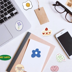Cute cartoon stickers with bears and flowers set on desk with laptop and notebook