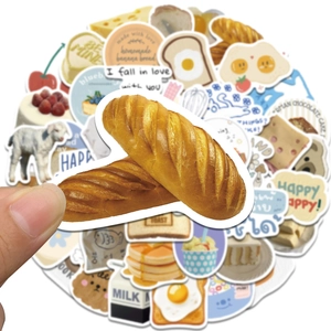 Close-up of a hand holding a cute bread sticker from a set for journal decoration