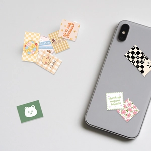 Detail of floral and checkered decorative stickers applied on a smartphone back cover