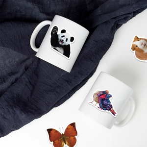 Close-up of animal stickers with panda and bird patterns on a white ceramic mug