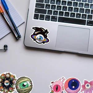 Vivaci adesivi graffiti a forma di occhio su un laptop con design artistici creativi