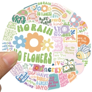Close-up of hand holding vintage aesthetic vinyl stickers with floral and rainbow motifs