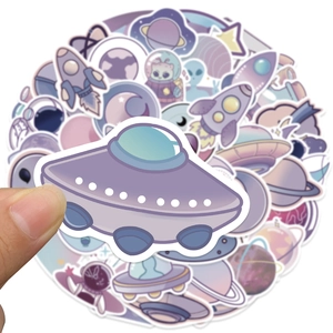 Detail of hand holding a purple UFO sticker from the alien space decal set
