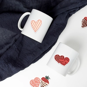 Detail of Valentine's heart stickers on a white ceramic mug set with chocolate patterns