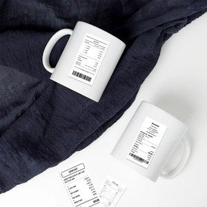 Detailed view of white ceramic mugs with creative black receipt pattern design