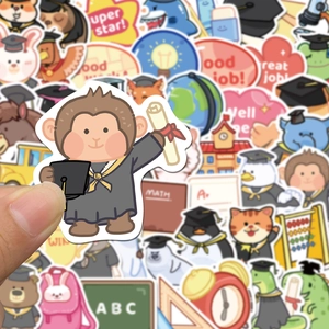 Close-up of hand holding a cartoon monkey graduation sticker among colorful reward decals